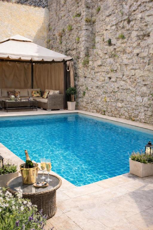 a swimming pool with a table and glasses of wine at Wisby Residence in Visby