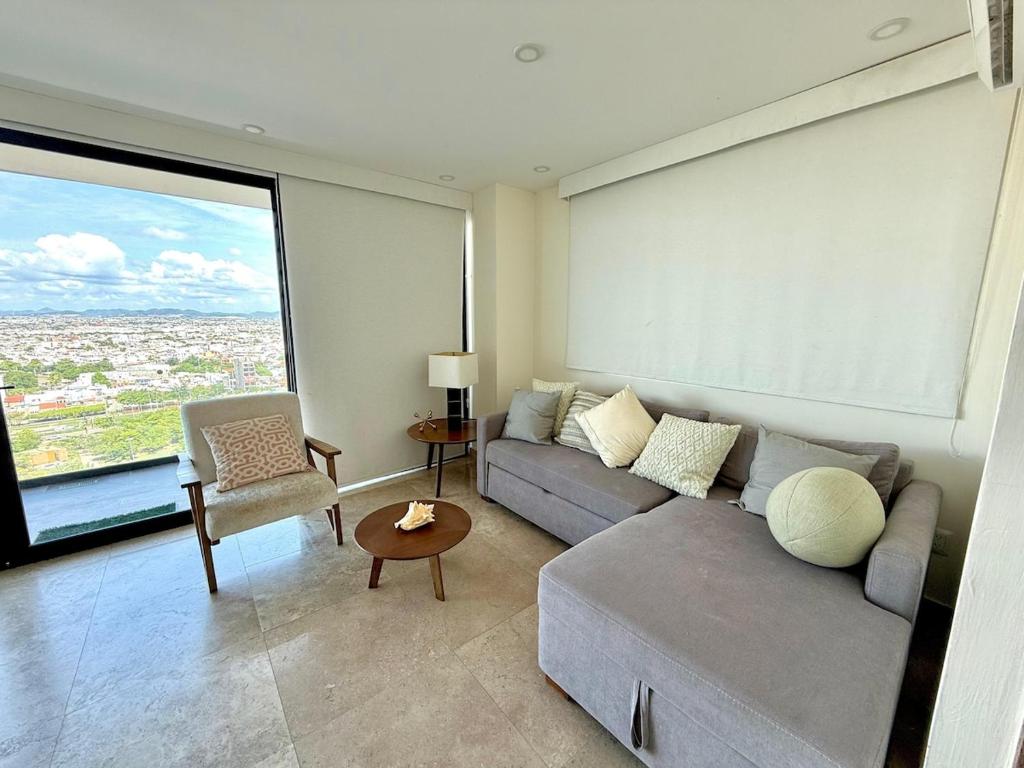 ein Wohnzimmer mit Sofa und großem Fenster in der Unterkunft Central 102 Malecón in Mazatlán