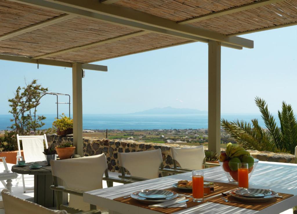 mesa de comedor con vistas al océano en AFOURA HOUSES by K&K, en Pirgos