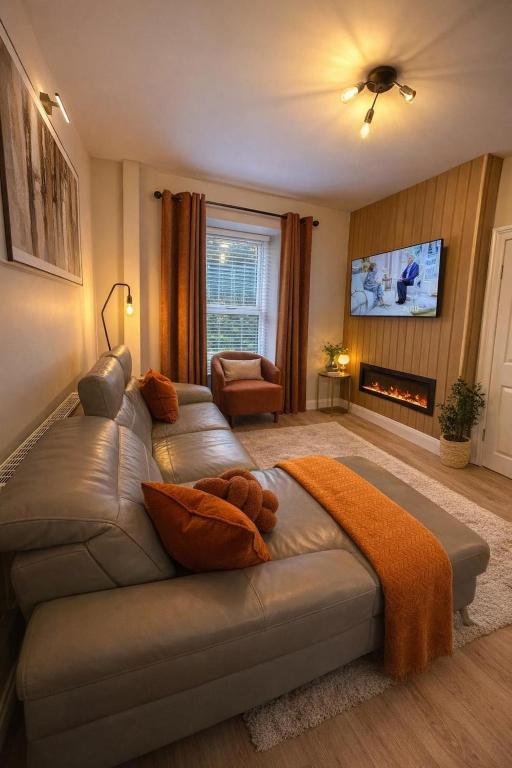 a living room with a couch and a tv at Derry City Centre Townhouse in Derry Londonderry