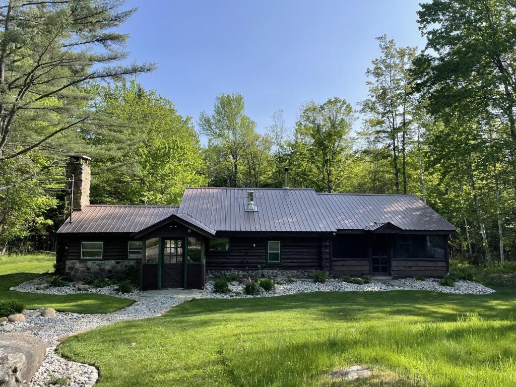 a log cabin in the middle of a yard at Minerva's Log Cabin Gem in Minerva