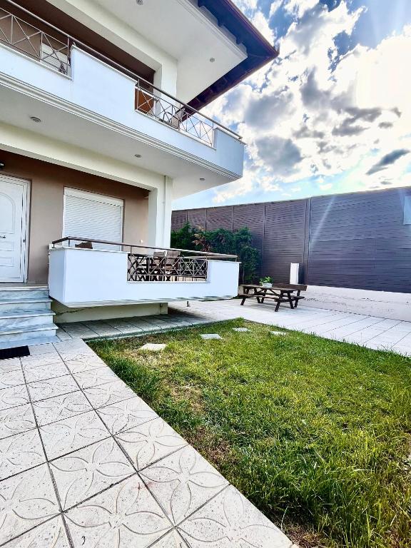 a house with a patio and a grass yard at Soso studios & apartments in Stavros