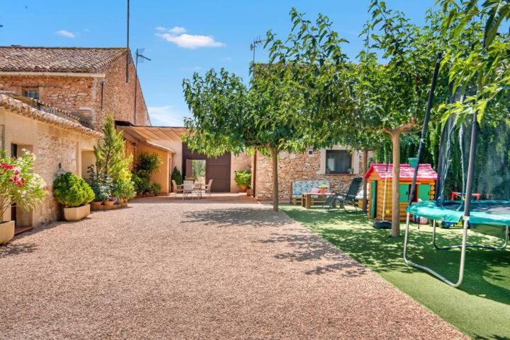 a garden with a swing and a house at Casa rural LA PEDANIA in El Salse