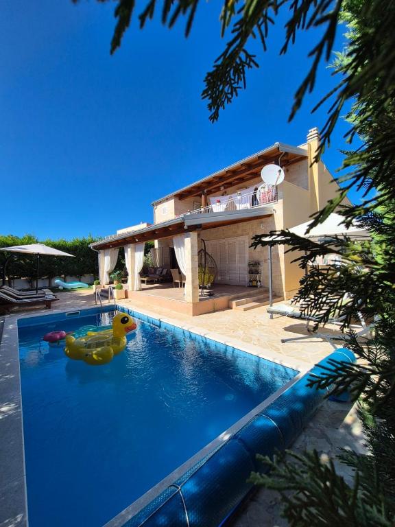 a swimming pool with two rubber ducks in the water at Villa Susann in Šibenik