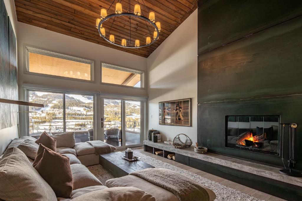 a living room with a couch and a fireplace at North Summit in Big Sky