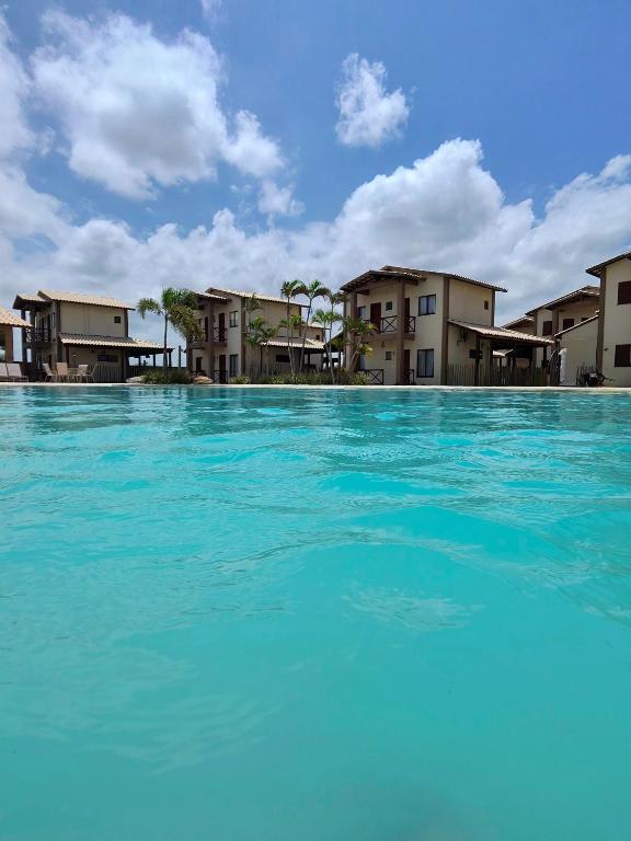 a large pool of blue water in front of buildings at Kite House Lençóis in Santo Amaro