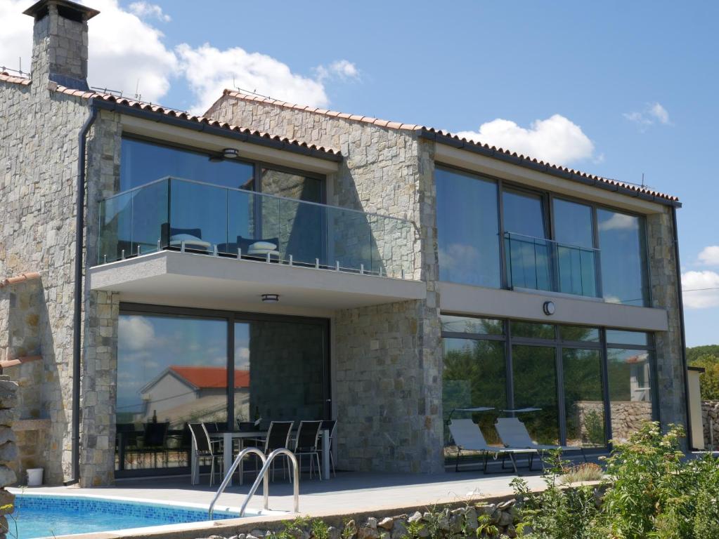 eine Villa mit einem Pool und einem Haus in der Unterkunft Villa Paradise in Vrbnik