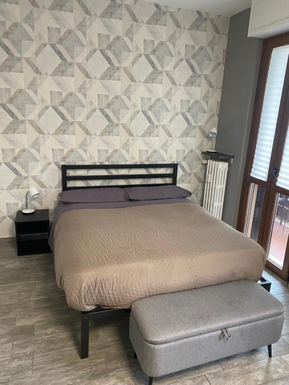 a bedroom with a king sized bed and a stone wall at Piccolo Paradiso in Novara