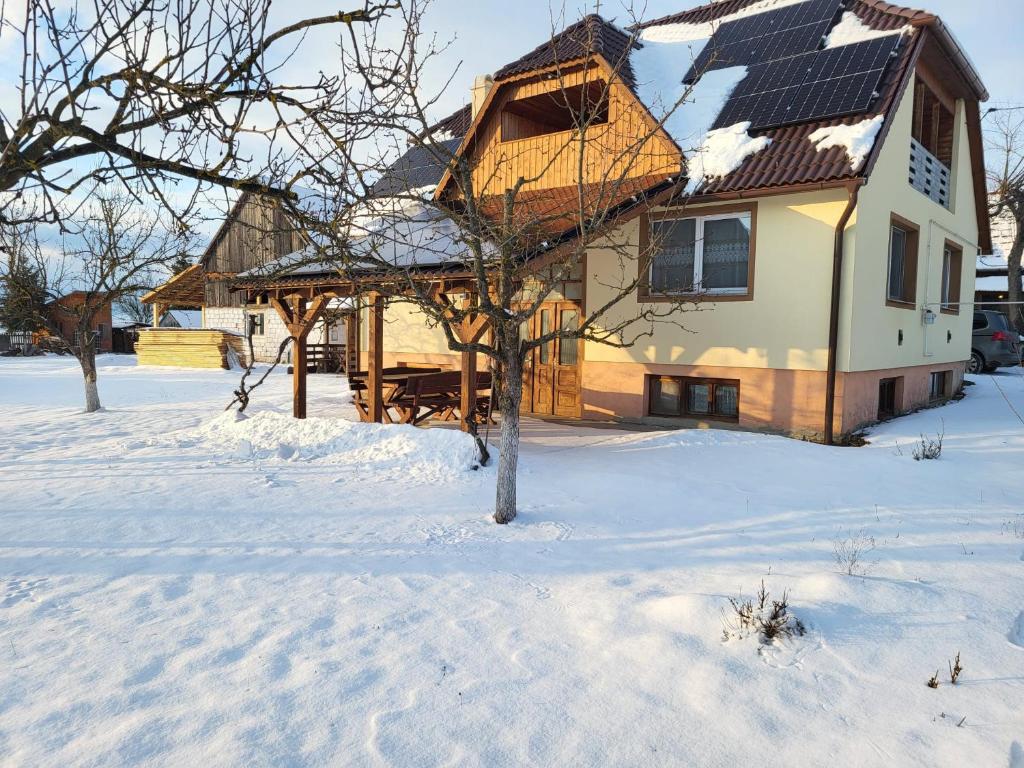 a house with a gazebo in the snow at Onodilak Guesthouse - Vendégház in Bîrzava