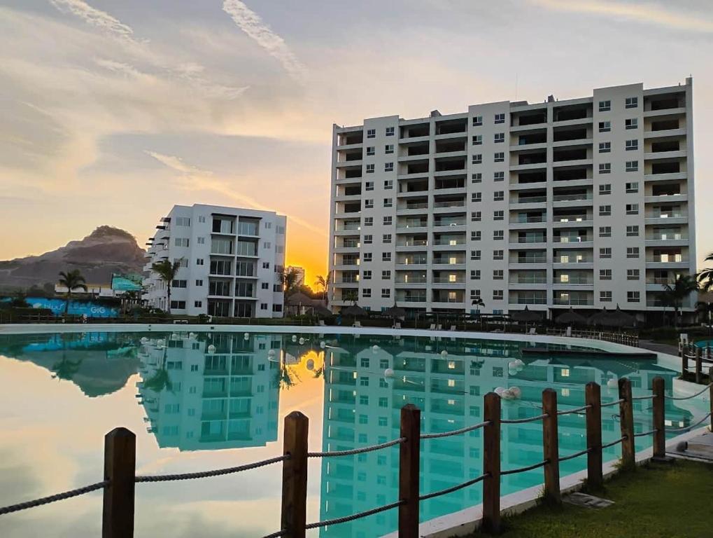 a large swimming pool with buildings in the background at Apartment with lagoon view mas amenities in Mazatlán