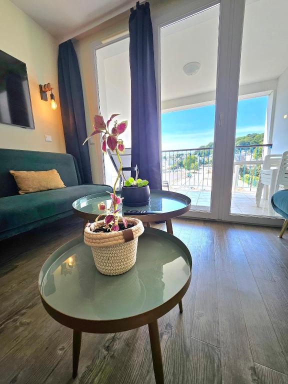 a living room with two tables and a couch at Le cosy des Sables Blancs in Douarnenez