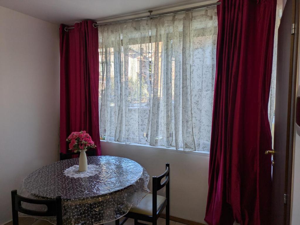 a table with a vase of flowers on it next to a window at Il Nido sul Torrente in Coazze