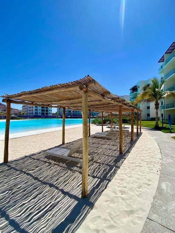 a wooden pavilion on the beach near the water at Premium apartment in Laguna Playa with pool in Mazatlán