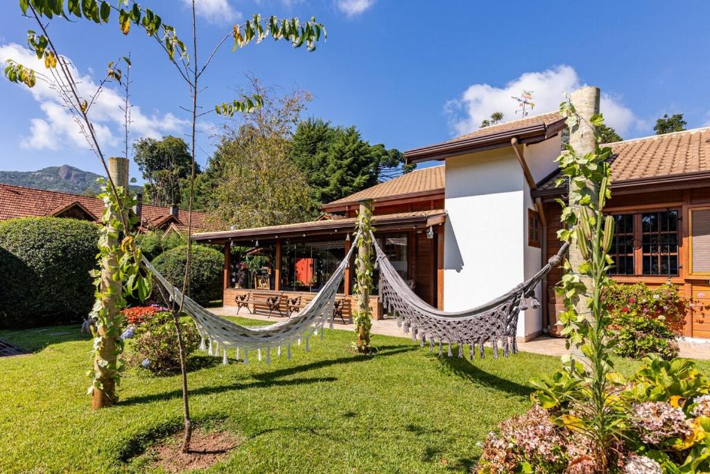 a hammock in the yard of a house at Refúgio de Montanha em Monte Verde para Famílias e Amigos com 4 Suítes in Monte Verde