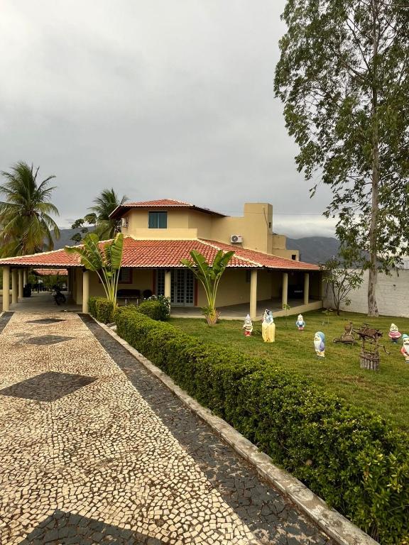 a house with chickens sitting in the grass in front of it at Chácara Rbs in Sobral