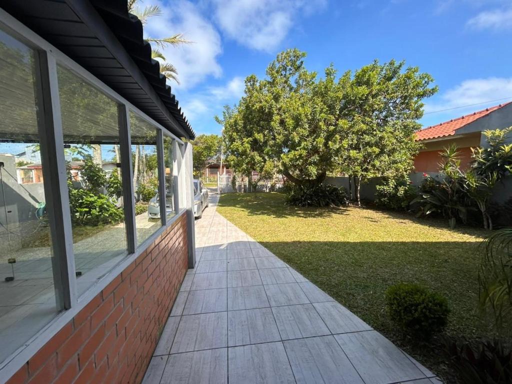 a house with a walkway next to a yard at Xangri-lá Beach House in Xangri-lá
