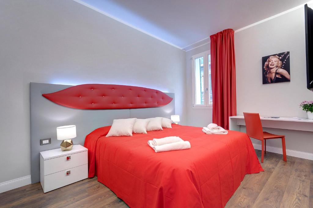 フィレンツェにあるDolce Vita Suiteの赤いベッド1台(上部に赤いパラシュート付)が備わるベッドルームです。