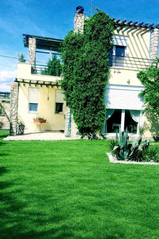 a house with a green lawn in front of it at Seaside Green Villa in Karianí