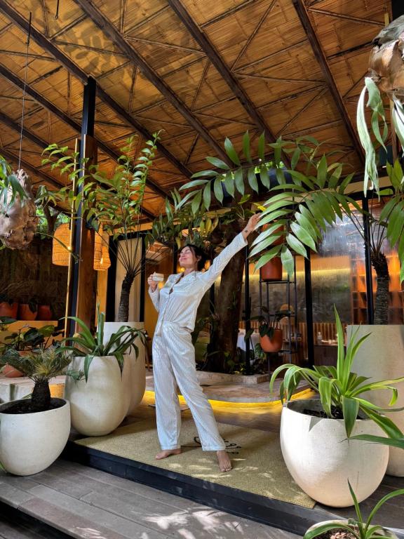 a man is standing in front of some potted plants at awā Beachfront Hotel in Puerto Viejo