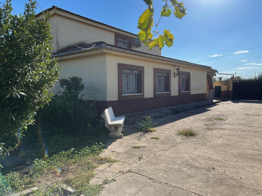 a house with a bench sitting outside of it at Casa familiar La Cabra in Talavera de la Reina