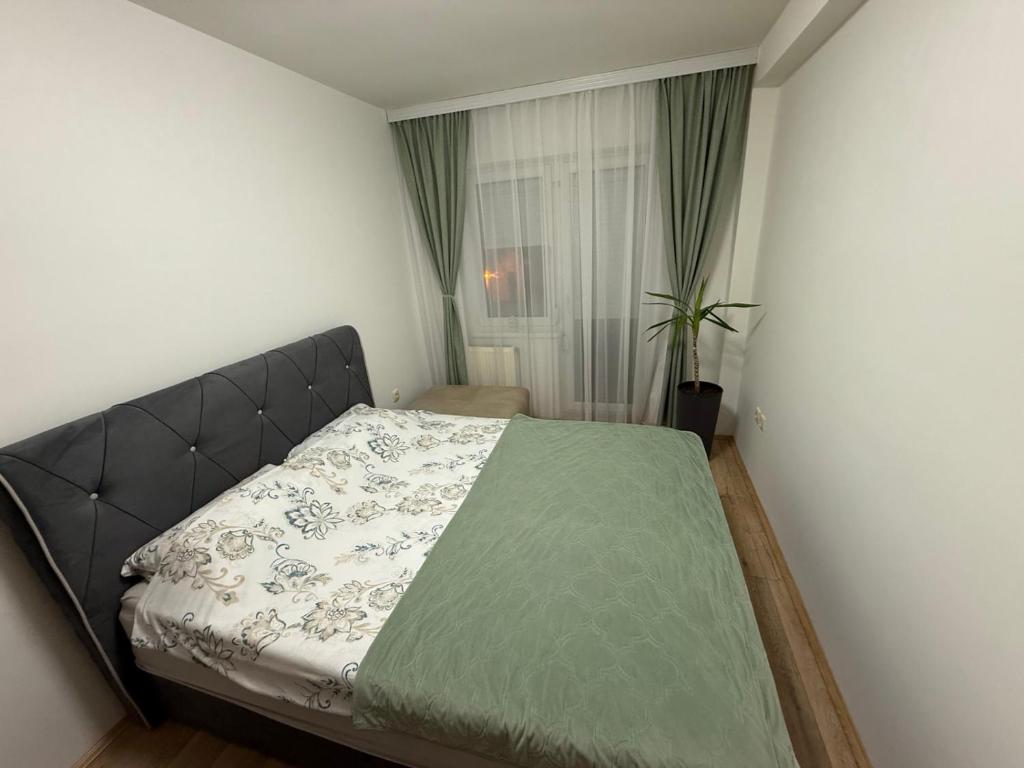 a bedroom with a bed with a green comforter at Apartman Odmor012-2 in Požarevac