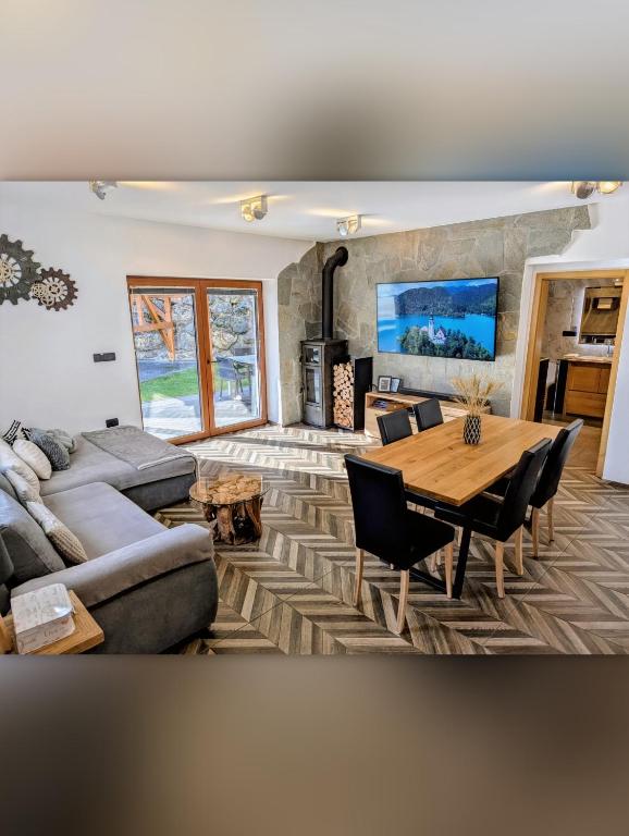a living room with a couch and a table at MY TIME BLED Holiday House with sauna in Zgornje Gorje