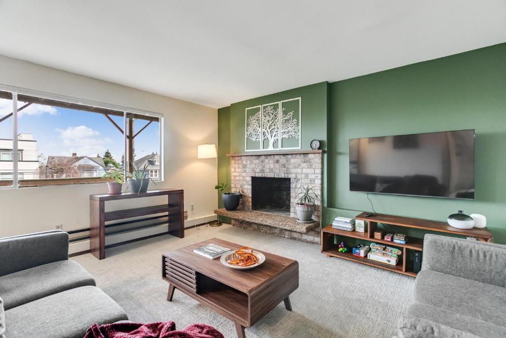 a living room with a fireplace and a flat screen tv at Cozy Hilltop Seattle Stay with Yard & Parking in Seattle