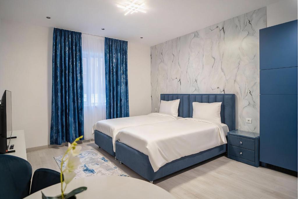 a bedroom with a king sized bed with blue curtains at LaRin Residence in Bucharest