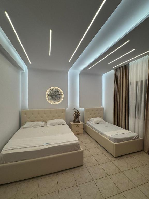 a bedroom with two beds in a room at Hotel Dragoi in Velipojë