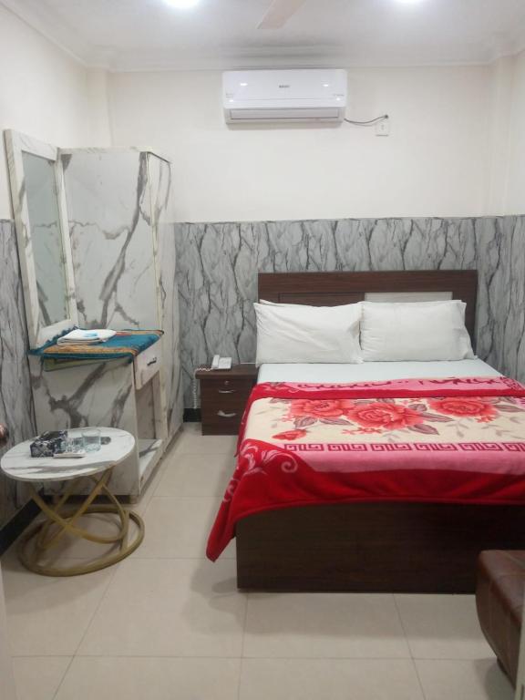 a bedroom with a bed with a red blanket at Sunrise BnB in Karachi