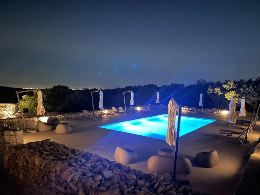 a large swimming pool at night with lights at DONNAPAOLA MODERN FARM in Altamura