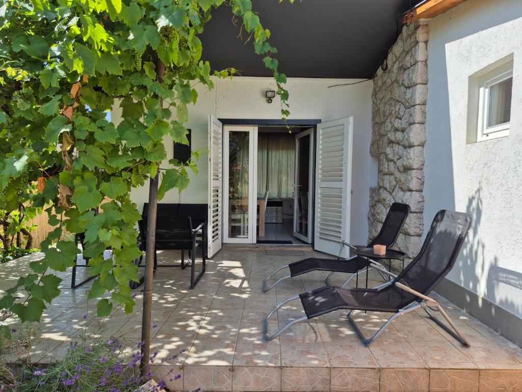 a patio with two chairs and a table at CsakMiKisház in Harkány