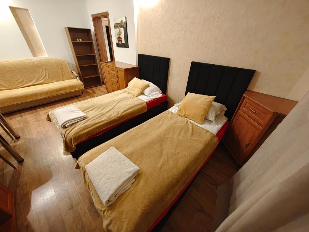 a room with two beds and a dresser at Vistula Home in Płock