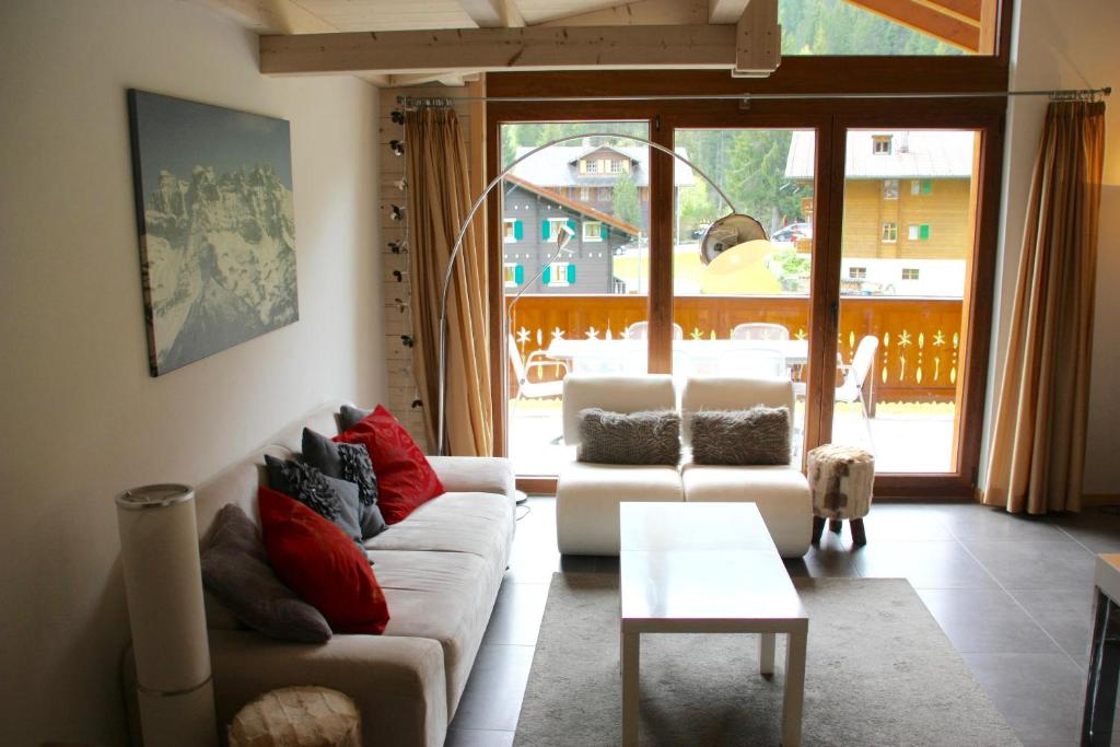 a living room with a couch and a table at Edelweiss B31 in Morgins