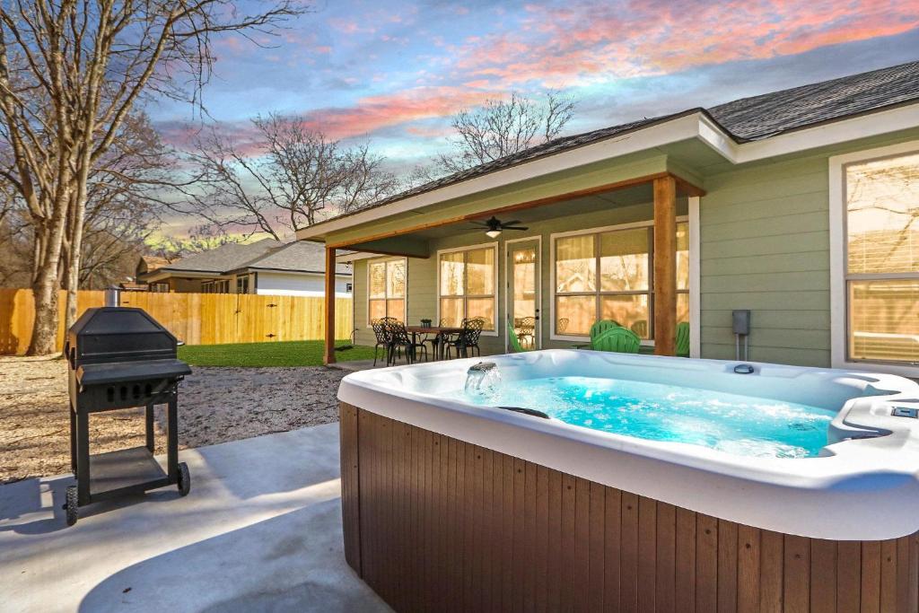 a hot tub in front of a house with a grill at The Tipsy Twins - Entire Property in Canyon Lake