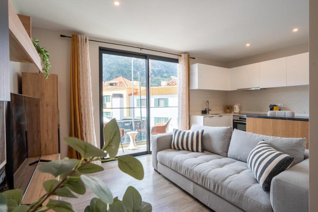 a living room with a couch and a kitchen at Golden Tide in Machico
