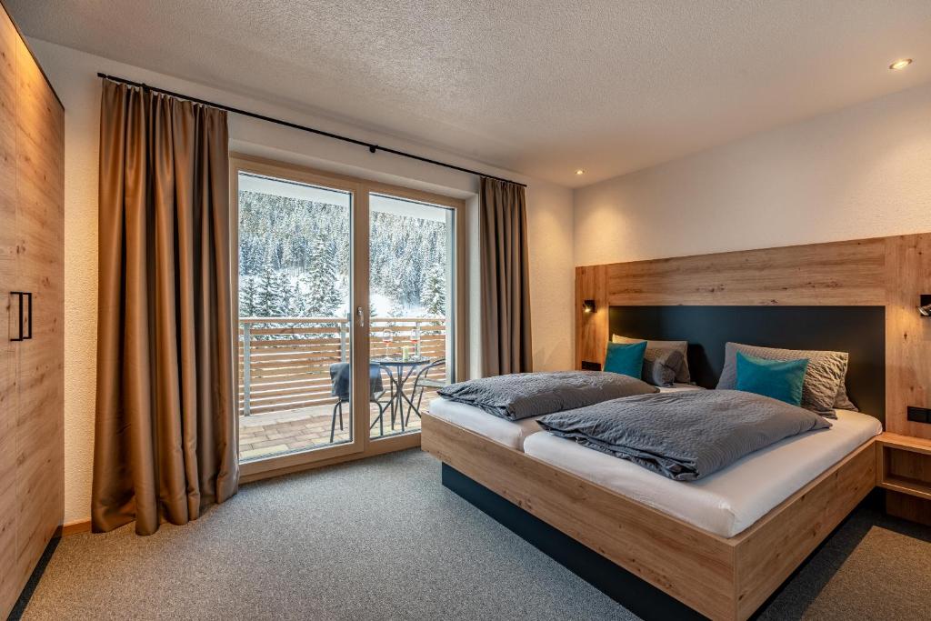 a bedroom with a bed and a large window at Ferienhaus Leo in See