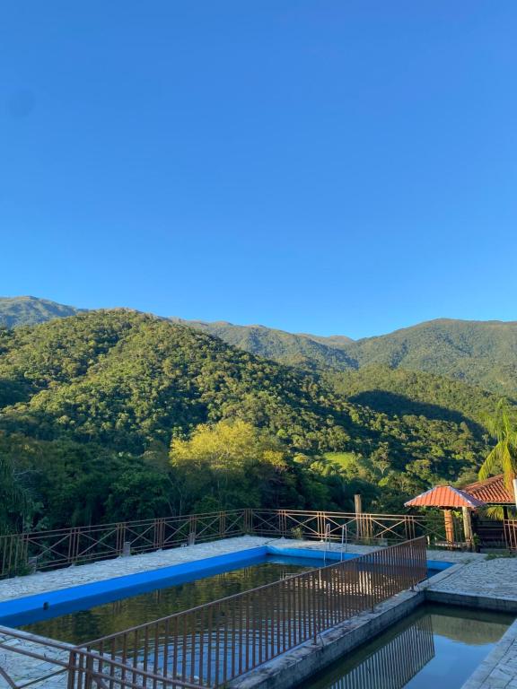 a swimming pool with a mountain in the background at Chalé aconchegante em Resende in Resende
