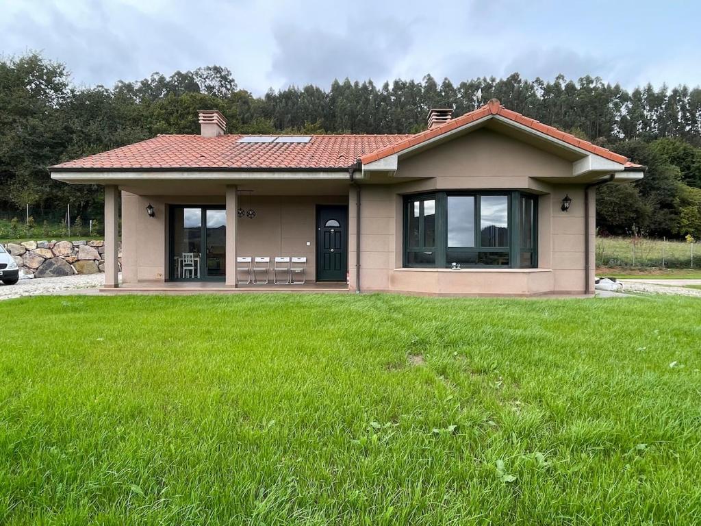 a small house with a green lawn in front of it at Casa Socias in Camoca