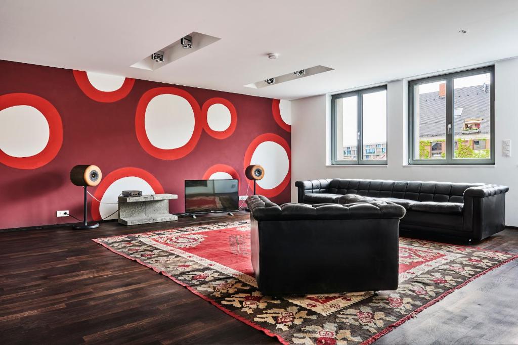 a living room with a red wall with white circles at no shoes hotel in Nuremberg