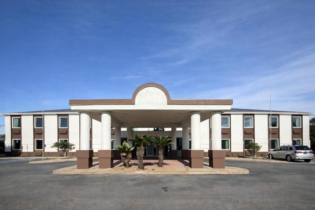 a large building with a parking lot in front of it at Regency Inn & Suites in Milton