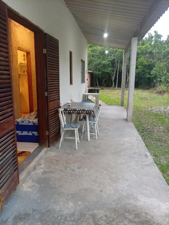 a patio with a table and chairs on it at Sol & mar Hospedagem - Boqueirão Sul Via Balsa Cananéia in Ilha Comprida