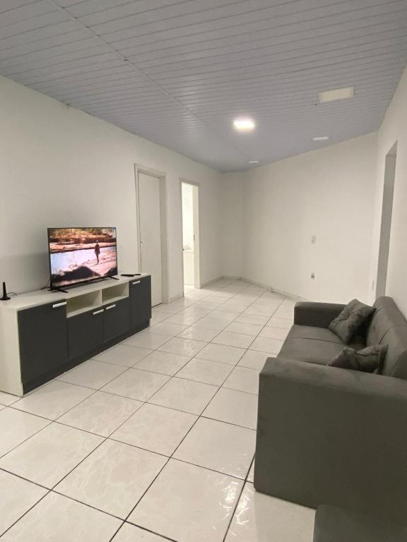 a living room with a couch and a flat screen tv at Apartamento com 3 quartos in Boa Vista