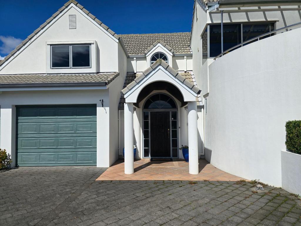 a white house with a garage at Island View in Tauranga