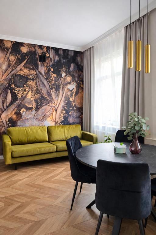 a living room with a yellow couch and a table at PIASKI 4 - Boutique stay in Gdańsk