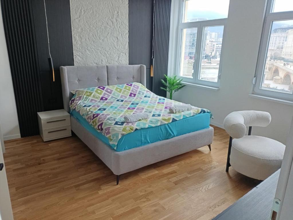 a bedroom with a bed and a chair at Stone Bridge 24 Apartment in Skopje