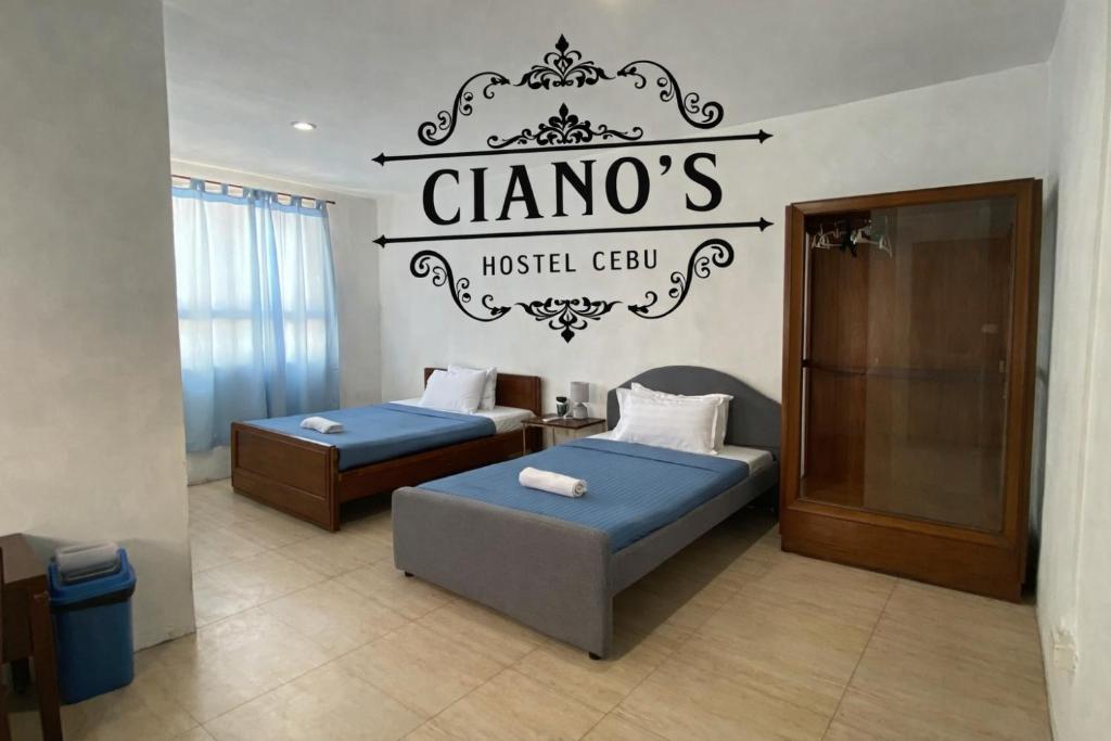 a room with two beds and a sign on the wall at Ciano's Hostel Cebu in Cebu City