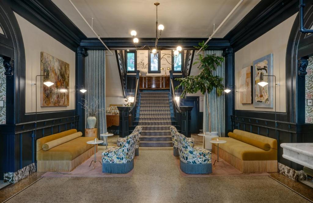 a lobby with blue walls and yellow couches and stairs at MarQueen Hotel - NEWLY RENOVATED in Seattle