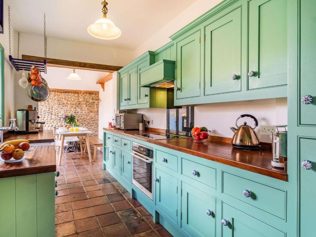 a kitchen with blue cabinets and a counter top at 3 Bed in Holt oc-87147 in Holt