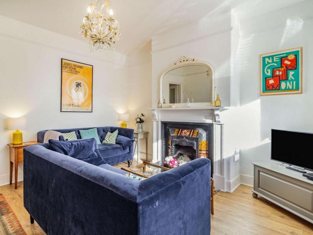 a living room with a blue couch and a fireplace at 4 Bed in Holt oc-87148 in Holt